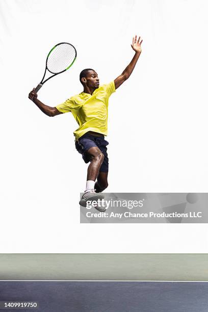 young tennis player leaps to hit a ball - tennis player stock pictures, royalty-free photos & images