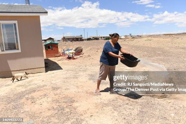 Geneva Black, of the Navajo Nation, dumbs out dirts dish water after doing dishes at her home on the Navajo Reservation on July 4, 2022 in Cameron,...