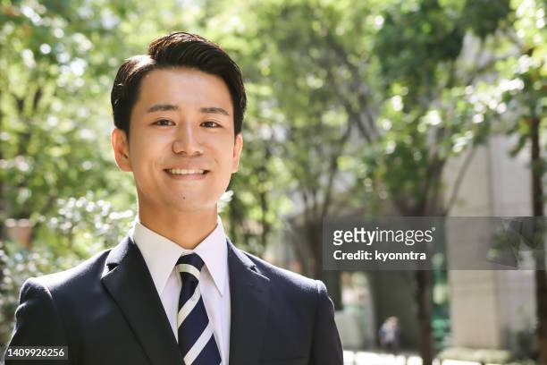 屋外で笑顔を持つ若いアジアのビジネスマンの肖像画 - japanese ストックフォトと画像