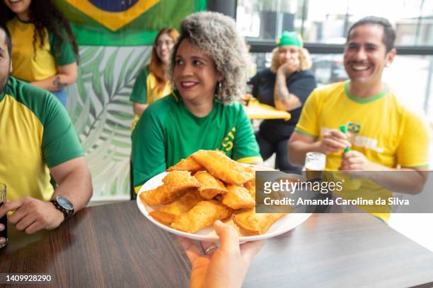 snack being served to a group of friends watching the soccer game in a bar - brazil culture stock pictures, royalty-free photos & images