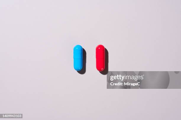 red and blue pills for choosing - decisions stock-fotos und bilder