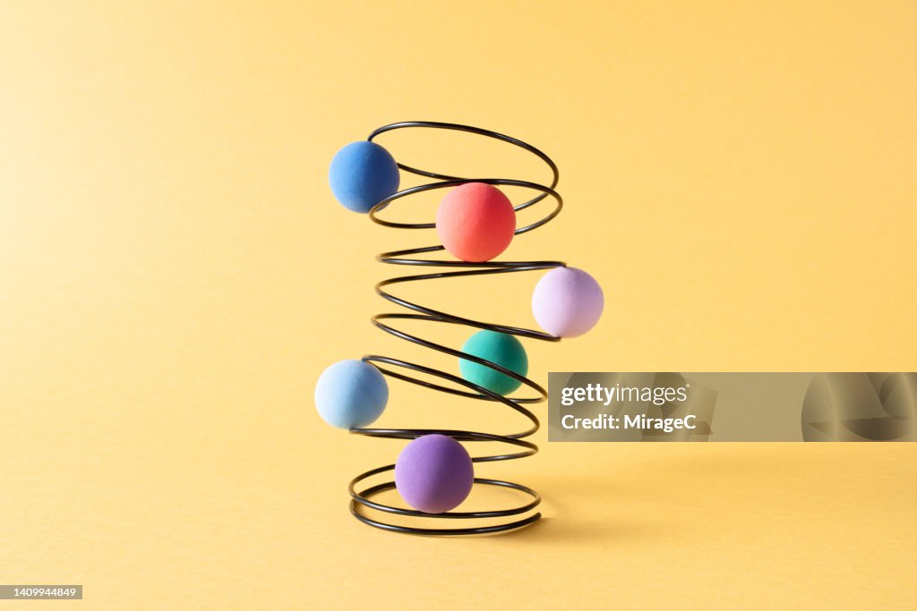 Colorful Spheres Embedded in a Swirl-shaped Coil Spring