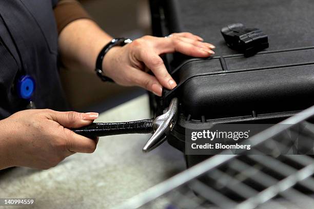 Worker installs latches while assembling an injection-molded plastic hardshell case at the Pelican Products Inc. Production facility in Torrance,...