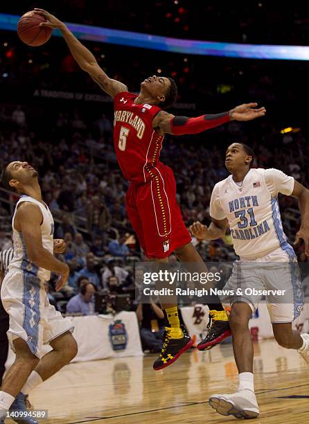 Maryland's Nick Faust looses control of the ball under pressure from North Carolina's Kendall Marshall and John Henson in the first half of their...