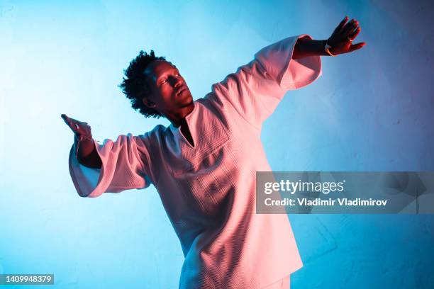 man dancing with arms held wide - japanese martial arts stock pictures, royalty-free photos & images