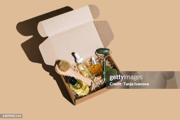 beauty box with face and body care products on beige background. - cosmetics box stock pictures, royalty-free photos & images