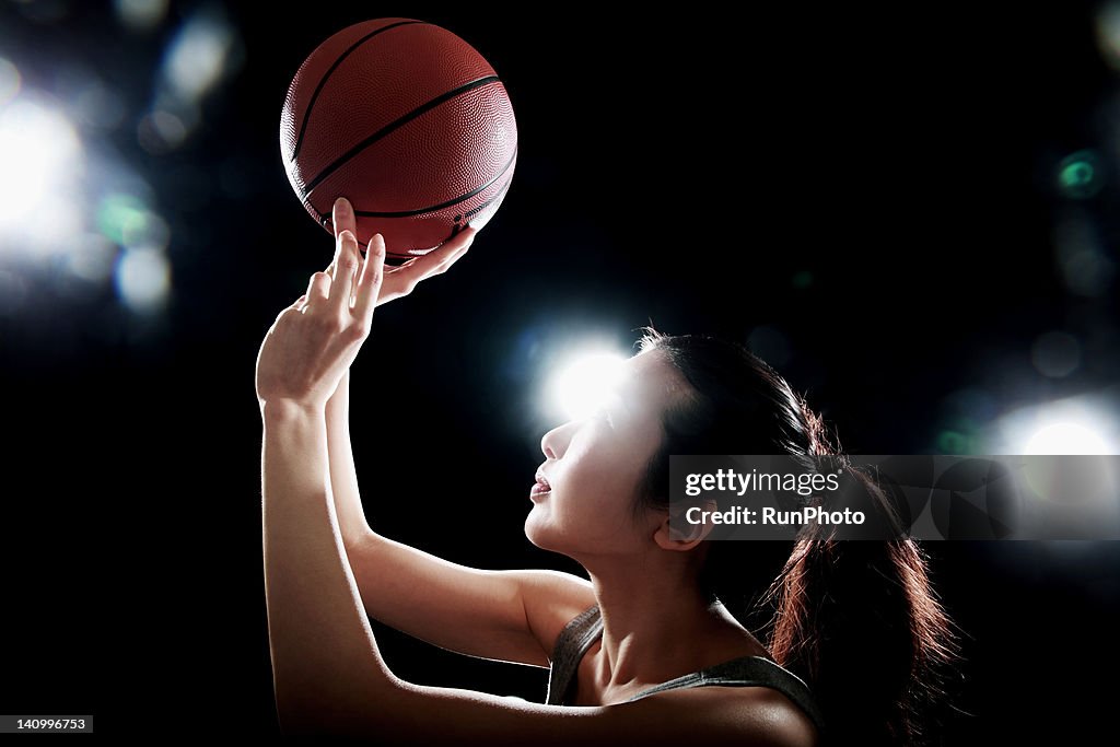 Young woman playing with basketball