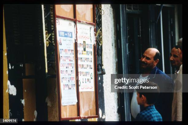 People look at a poster for the upcoming local elections October 22, 1997 in Algeria. Angered by the suppression of the Islamic Salvation Front when...