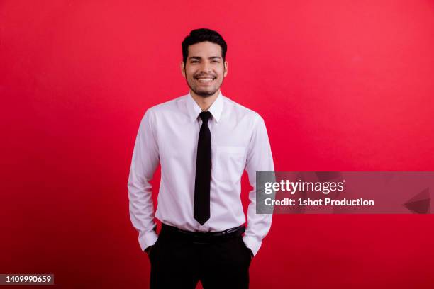 happy smiling laughing middle east man portrait in red background. - red shirt stockfoto's en -beelden