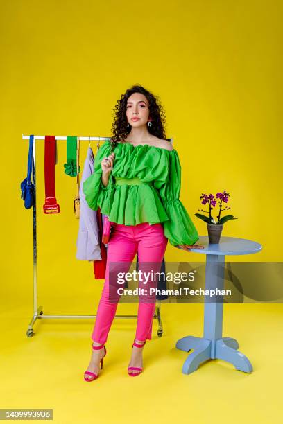 woman standing in front of clothes on clothes rack - ファッションスタイリスト ストックフォトと画像