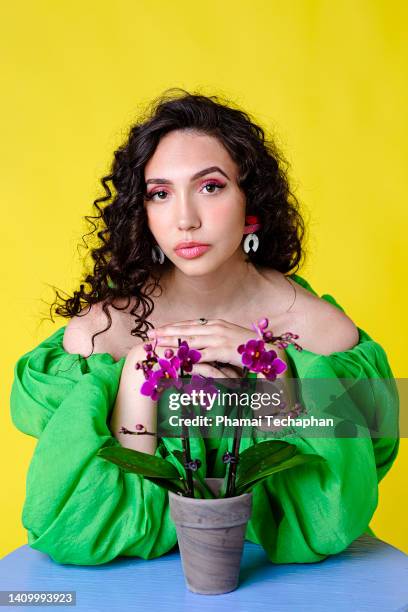 beautiful woman sitting at a table - floral blouse stock pictures, royalty-free photos & images