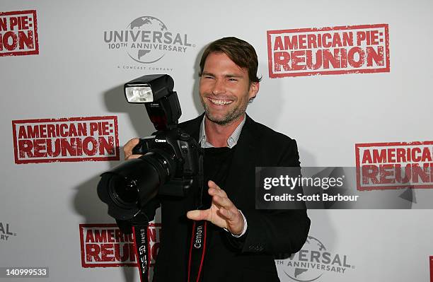 Seann William Scott takes a camera from a photographer as he arrives at the Australian premiere of "American Pie: Reunion" on March 7, 2012 in...