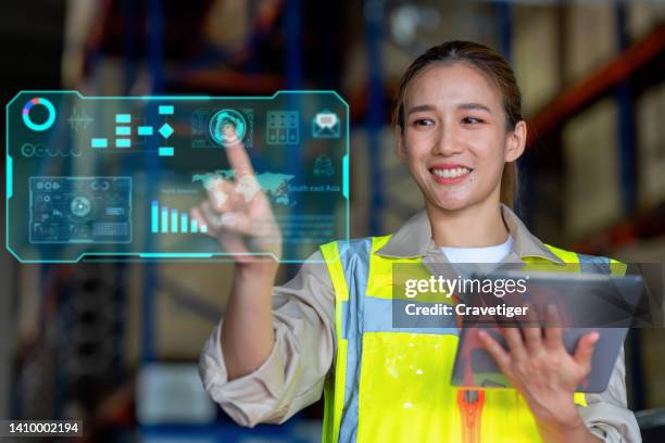 female warehouse officer use the digitization display by synchronize  with digital tablet for check the information of globalization customer transportation in the factory . globalization business transport information. - distribution warehouse stock-fotos und bilder