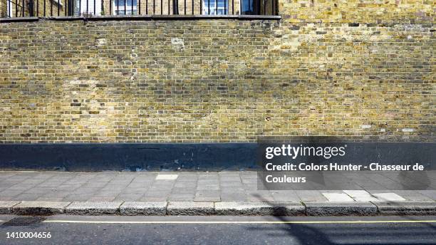 an empty street and pavement in central london (city of westminster), england, uk, with a weathered brick wall - pavement stock pictures, royalty-free photos & images