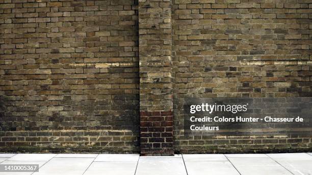 patinated empty dark brown brick wall with new clean pavement london (city of westminster), england, uk - new pavement stock pictures, royalty-free photos & images
