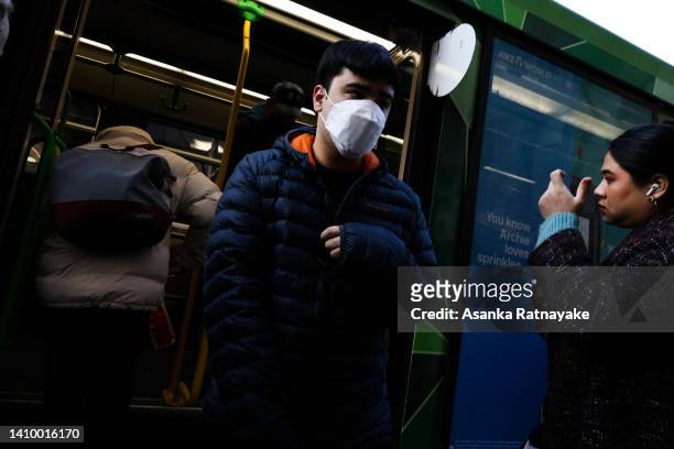 Person wearing a mask gets off a tram on July 21, 2022 in Melbourne, Australia. Victoria recorded 14,312 official cases of COVID-19 in the last...