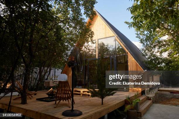 timber frame house with garlands building exterior view through trees - cottage exterior stock pictures, royalty-free photos & images