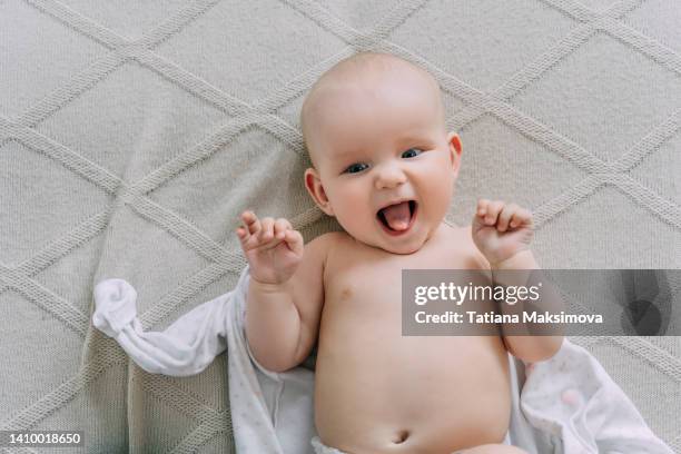cute nude baby is lying on a light beige blanket at home. - mes fotografías e imágenes de stock