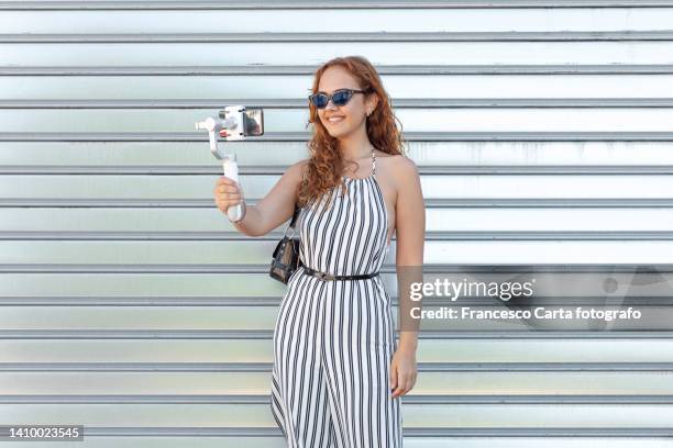 woman vlogger is talking to her fans - striped dress ストックフォトと画像