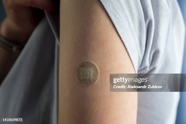 a girl or a woman holds her hand, which is covered with a plaster or band-aid after vaccination or injection of medication. the concept of medicine and healthcare, prevention and treatment of diseases. first aid. repeated vaccination, revaccination. - needle injury stock pictures, royalty-free photos & images