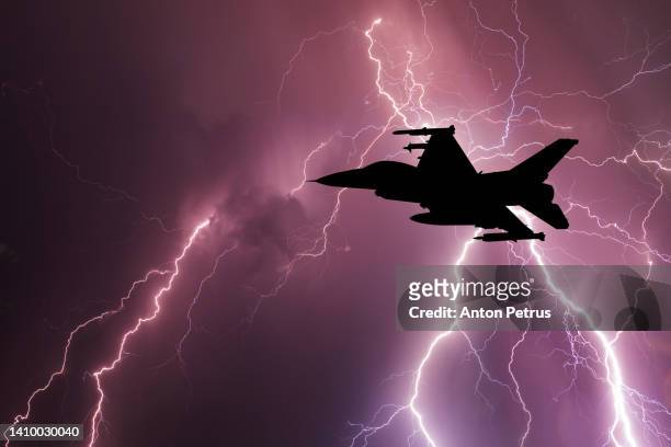 fighter on the background of a thunderstorm. military aviation - luchtaanval stockfoto's en -beelden