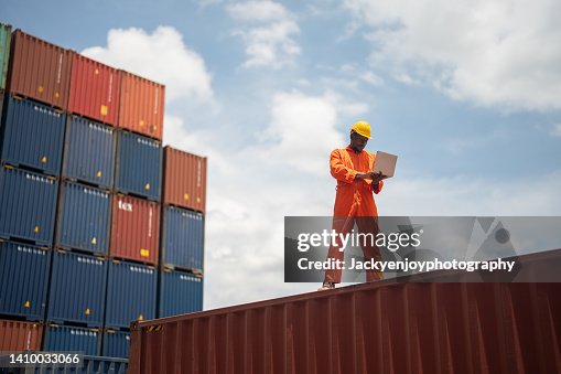 Workers using laptops while working next to shipping containers Workers using laptops while working next to shipping containers