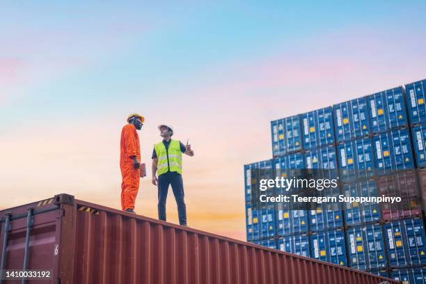 standing and conversing workers at a commercial port - containerhafen stock-fotos und bilder