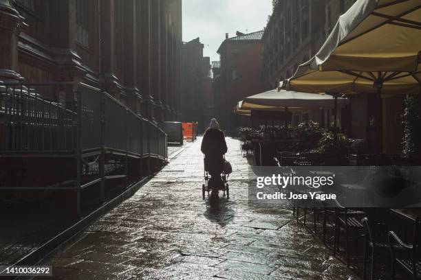 woman walking with a baby stroller in the rain - baby pram in the park stock pictures, royalty-free photos & images