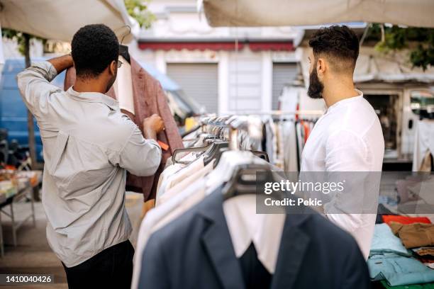 friends buying clothes in thrift store - sustainable clothing stock pictures, royalty-free photos & images