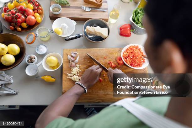 young man preparing healthy meal on kitchen counter - chopping stock pictures, royalty-free photos & images