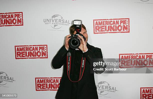 Seann William Scott takes a camera from a photographer as he arrives at the Australian premiere of "American Pie: Reunion" on March 7, 2012 in...