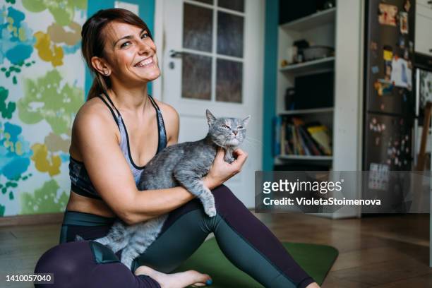 sporty woman exercising at home. - cat and owner stock pictures, royalty-free photos & images