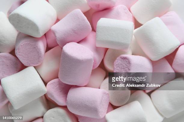 beautiful sweet airy delicate white and pastel pink marshmallows lie on a plate, on a wooden table. the concept of food and unhealthy eating. food background. dependence on sweet food. - marshmallow stock-fotos und bilder