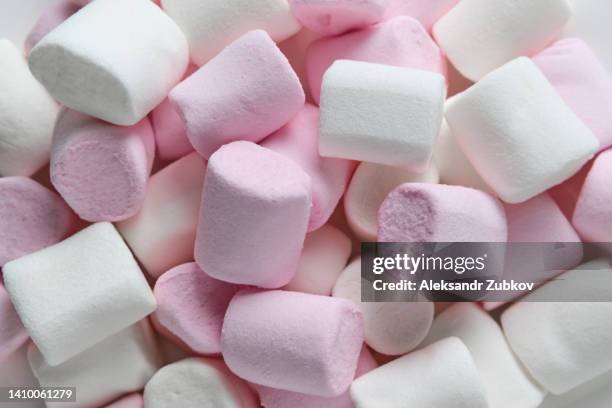 beautiful sweet airy delicate white and pastel pink marshmallows lie on a plate, on a wooden table. the concept of food and unhealthy eating. food background. dependence on sweet food. - marshmallow stock pictures, royalty-free photos & images