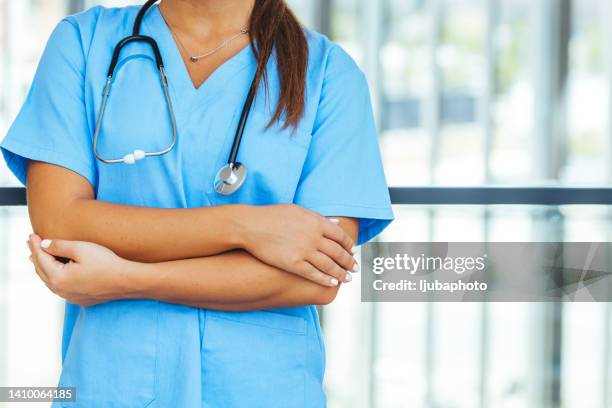 female medicine nurse hands crossed on her chest in office. - torso stock pictures, royalty-free photos & images