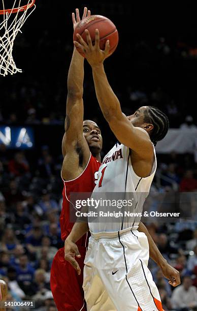 State guard Lorenzo Brown blocks a first half shot by Virginia guard Jontel Evans as N.C. State played Virginia in the quarterfinal round of the ACC...