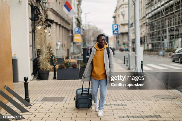 african-american man walking through the city - pulling stock pictures, royalty-free photos & images