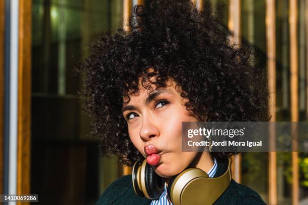 woman grimacing while looking up outdoors - self doubt ストックフォトと画像