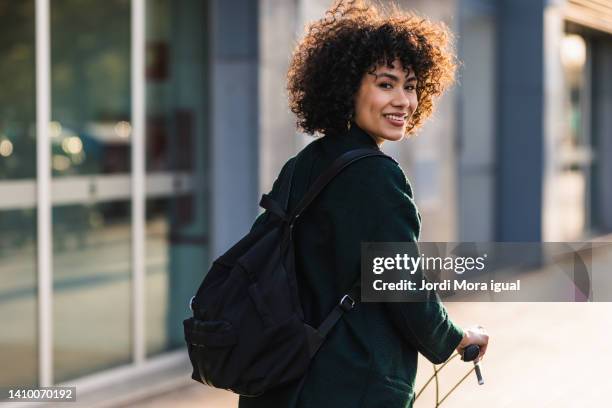 woman riding a bike turning to smile to the camera - vitaliteit fiets stockfoto's en -beelden