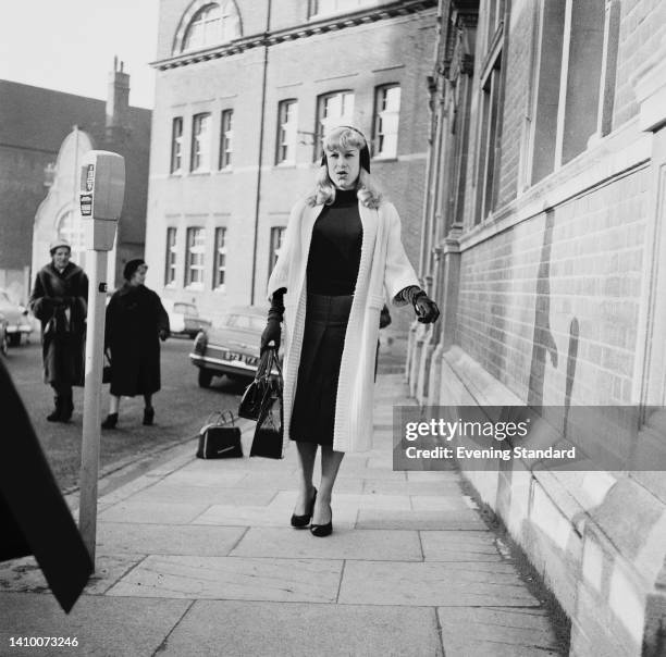 British racing driver Roberta Cowell , wearing a black outfit beneath a white coat, outside Croydon County Court in Croydon, London, England, 2nd...