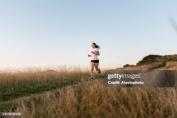 woman running in the field - running shoes sky stock pictures, royalty-free photos & images