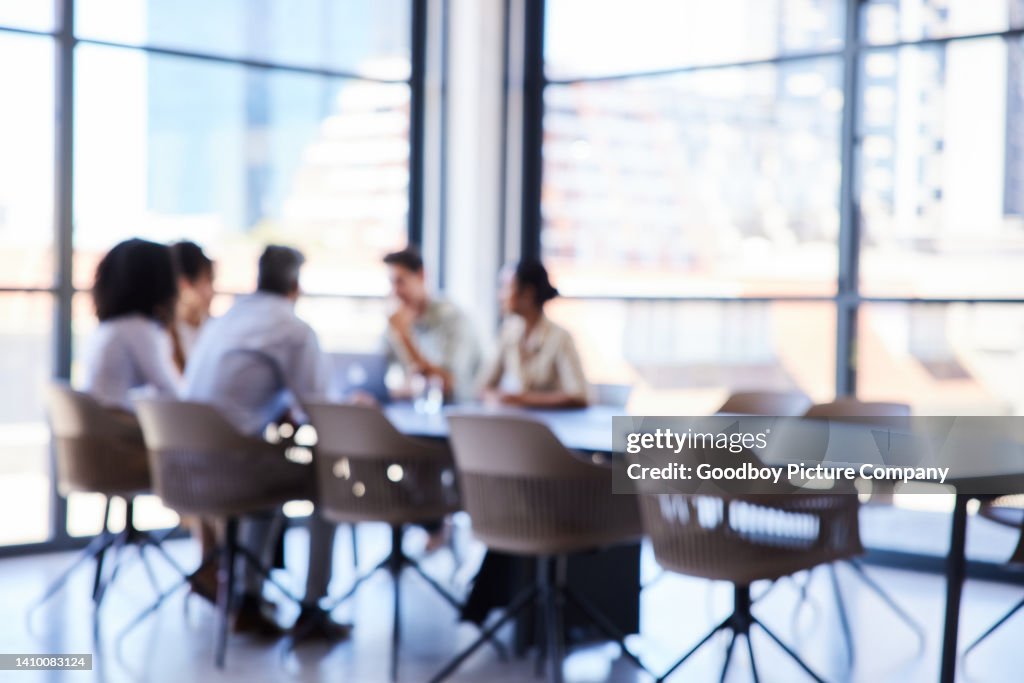 Unrecognizable businesspeople having a meeting at a boardroom table in an office