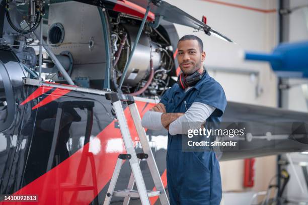 male mechanic standing in hangar - red jumpsuit stock pictures, royalty-free photos & images