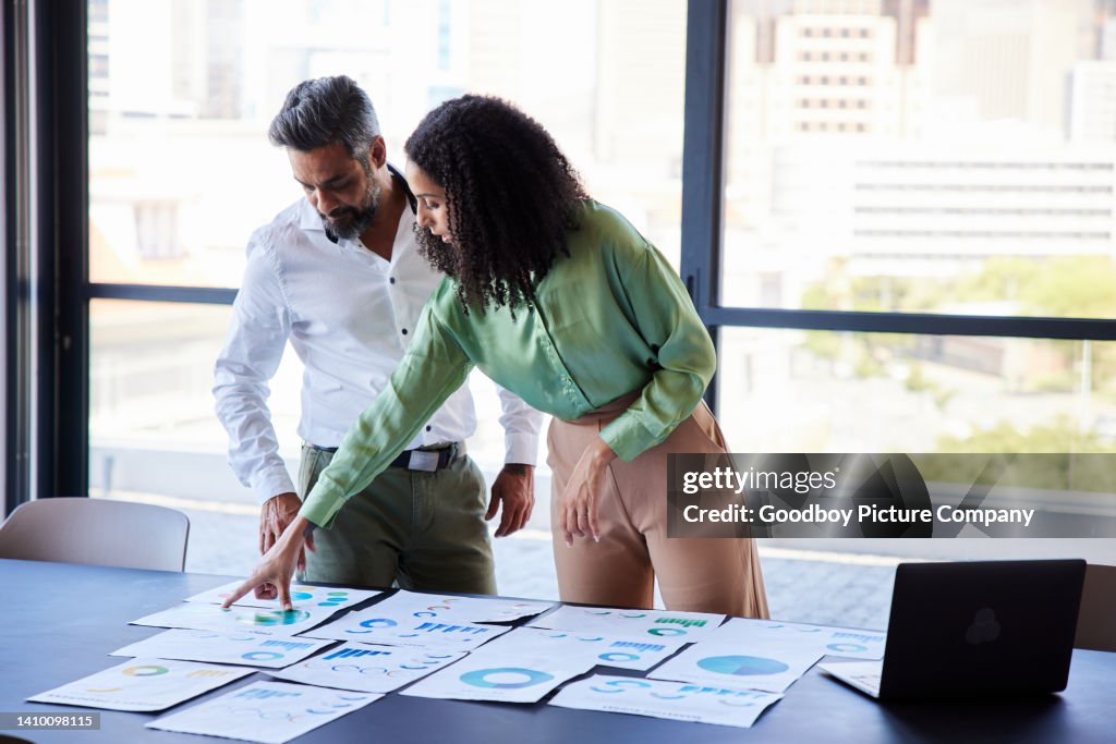 Businesspeople discussing charts and graphs on a boardroom table