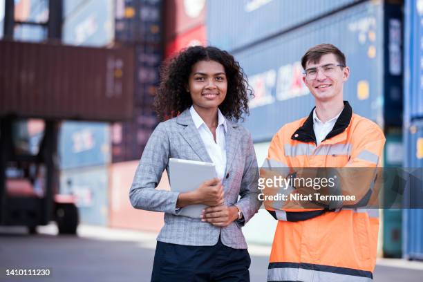 the global logistics supply chain management and international trade. a multi-ethnic logistics provider is working at a commercial dock with cargo containers stacked. they're experts in logistics operations support. - global business continuity stock pictures, royalty-free photos & images