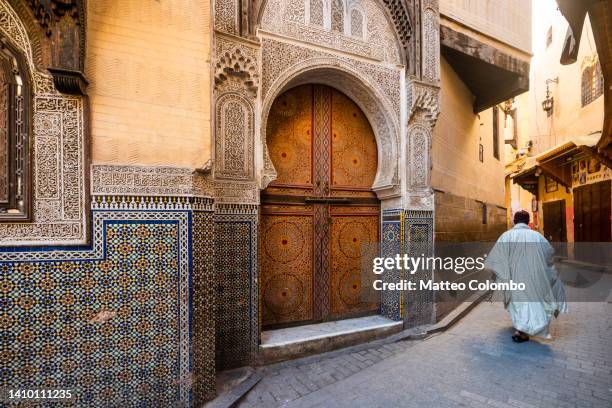 man in the streets of the medina, fes, morocco - fez morocco stock pictures, royalty-free photos & images