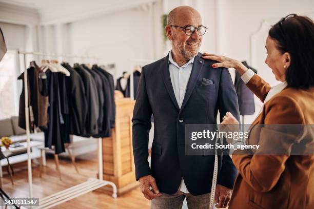 tailor taking measurements - fato imagens e fotografias de stock
