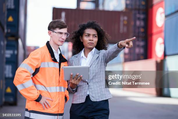 improved customer satisfaction in logistics supply chain management. a multi-ethnic logistics operation manager and port supervisor at a shipping port while discussing improving operational systems, and processes. - funcionário de alfândega imagens e fotografias de stock