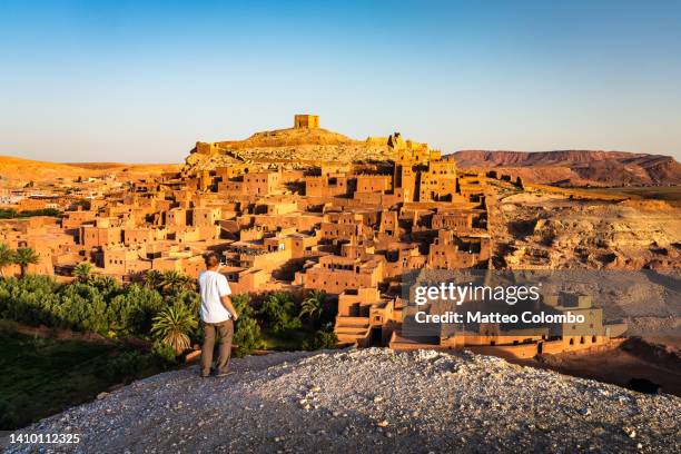 man at ait benhaddou at sunrise, morocco - casbah stock pictures, royalty-free photos & images