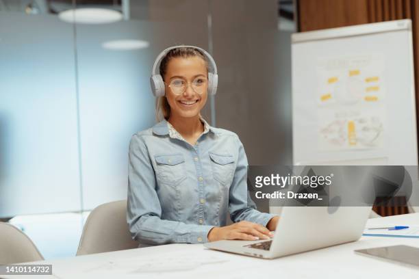 junger mitarbeiter im büro, arbeitet am laptop - facial expression girl office stock-fotos und bilder